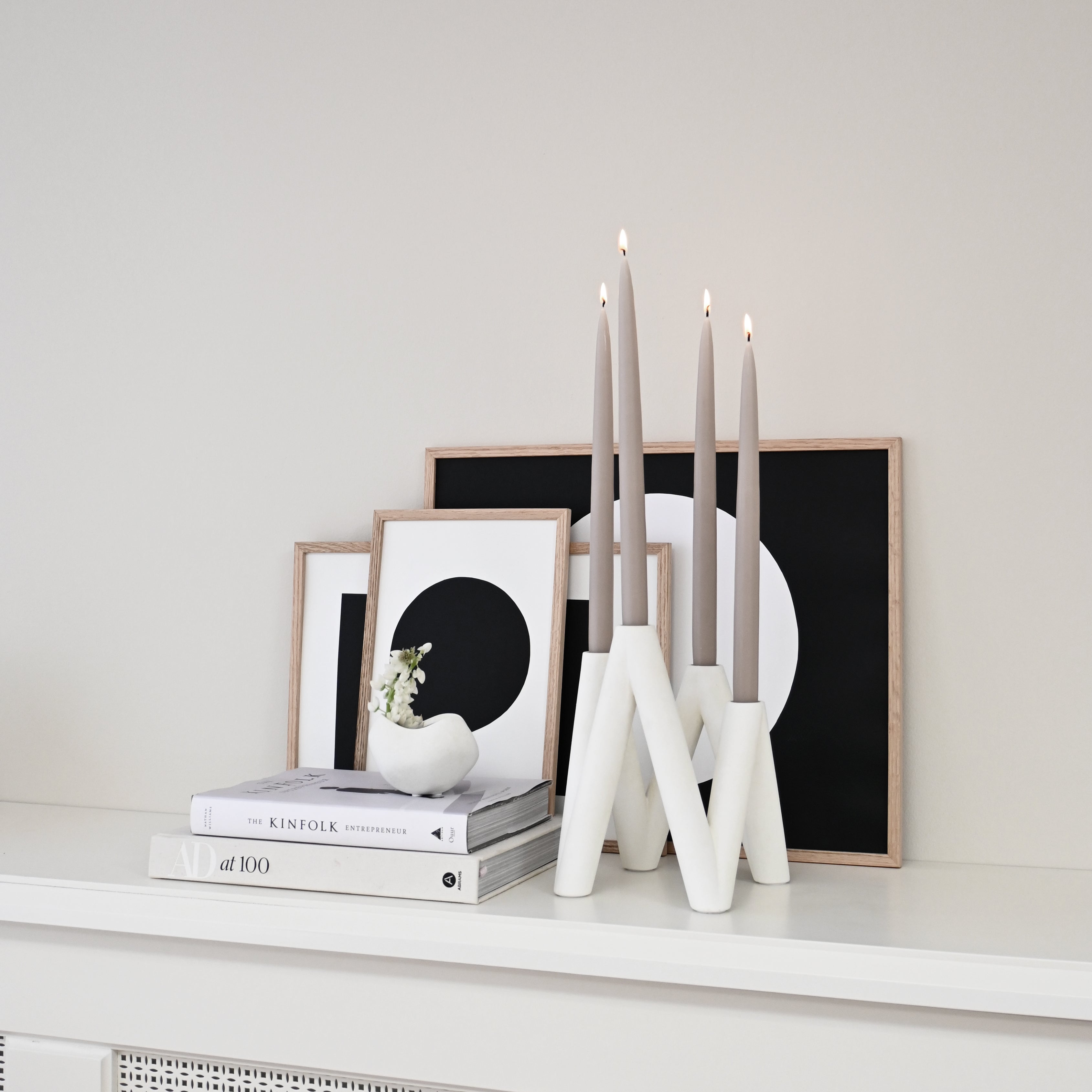W Candle Holder - Bone White with lit candles by books and framed images