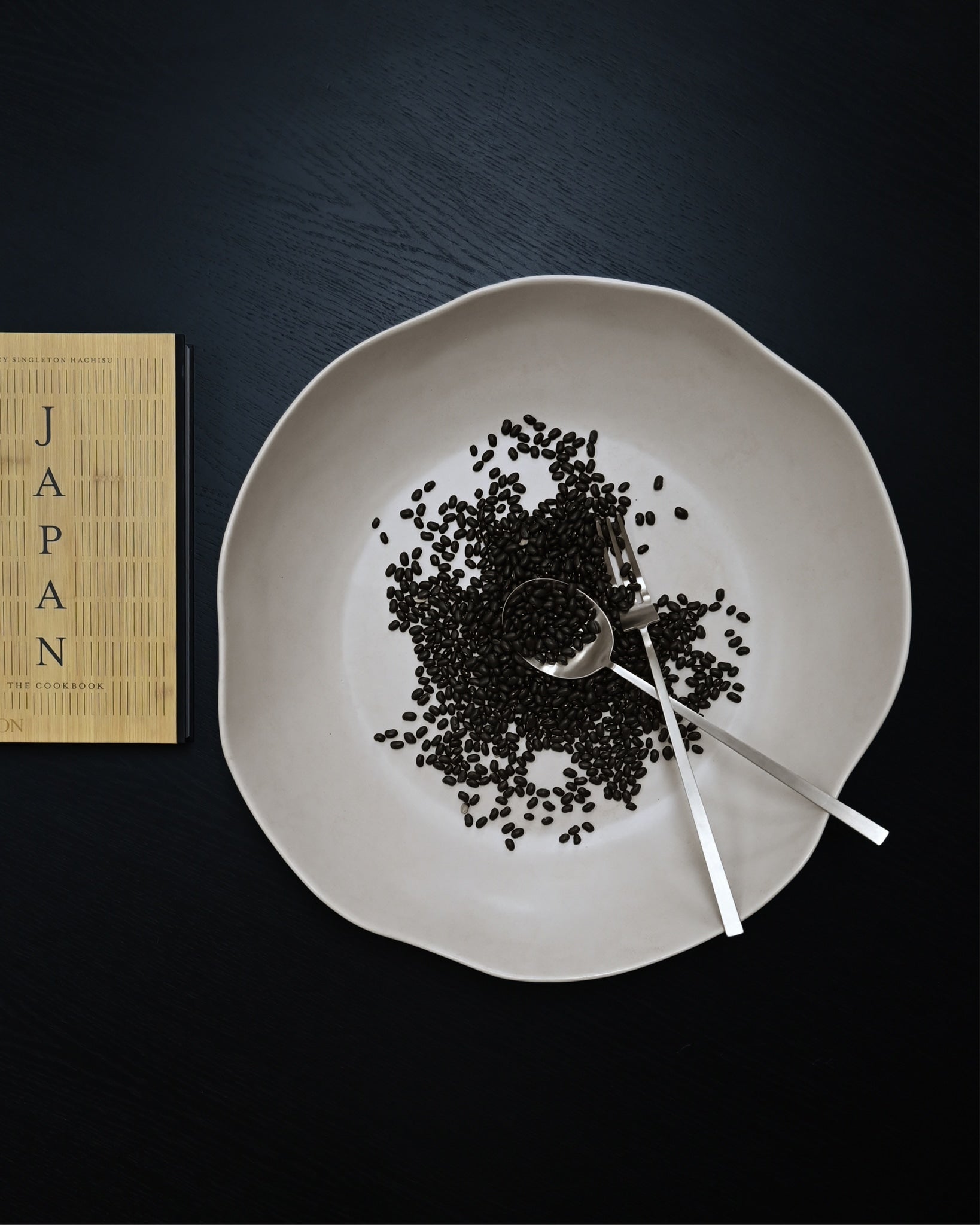 101 Copenhagen Kogei Salad Servers - Brushed Steel in Native Tray Hexa with black seeds
