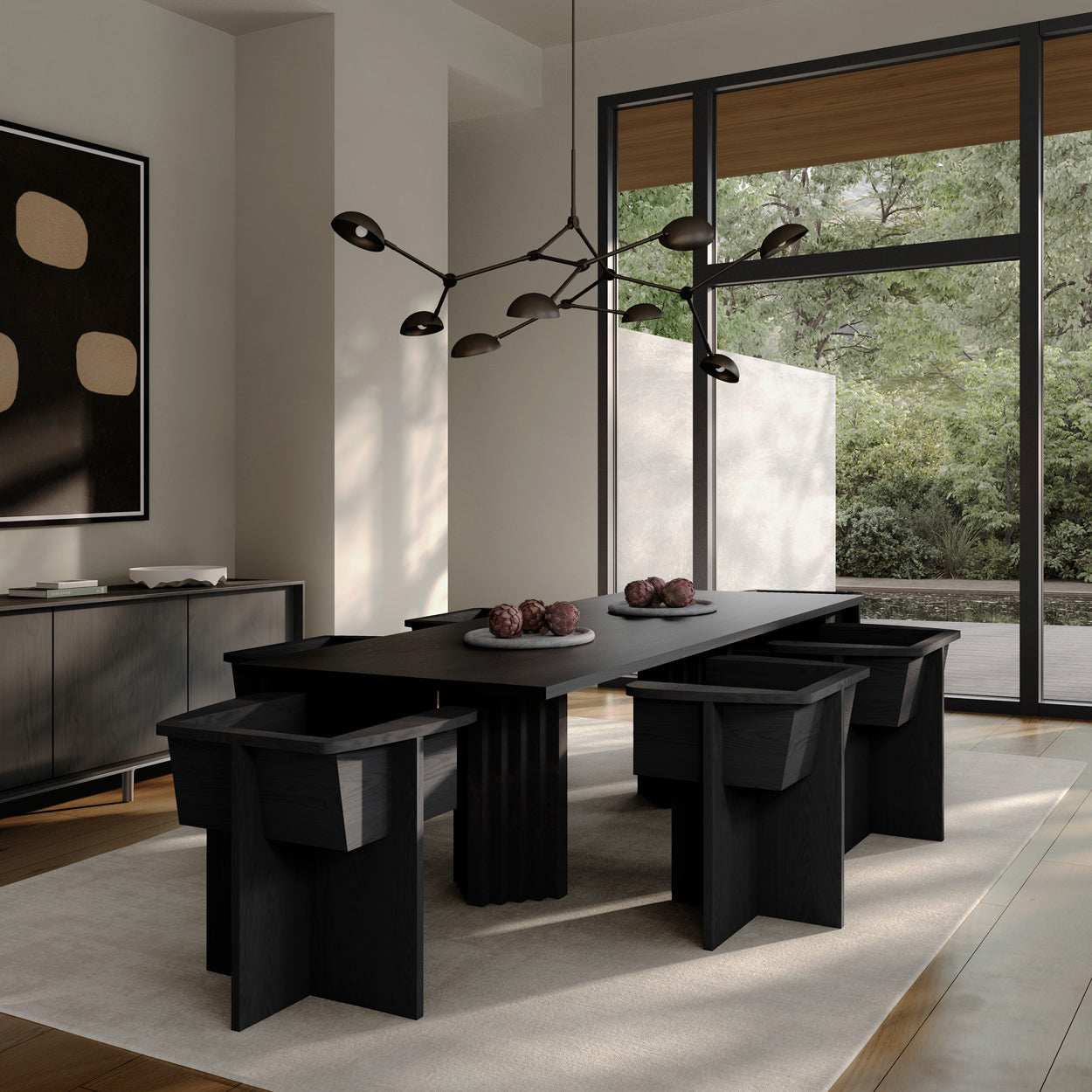 Modern dining room with Arc table and Brutus dining chairs in a bright room with large windows and a Drop Chandelier.